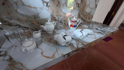 a marble counter with tea pots and cups on it at Kulassa Homes in Anuradhapura