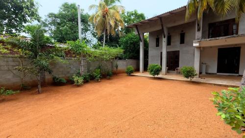 a house with a dirt road next to a building at Kulassa Homes in Anuradhapura
