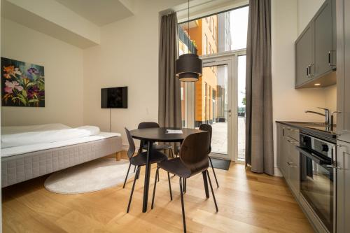 a kitchen and dining room with a table and chairs at Hotel Lille Nyhavn in Skanderborg