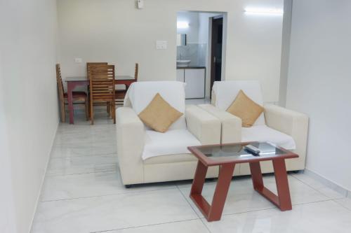 a living room with two chairs and a coffee table at Vajra Periyar Heritage in Alwaye