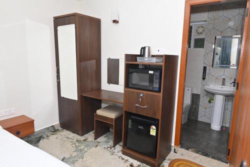 a room with a bathroom with a tv and a sink at Bluevalley Estate - Three Bedroom Villa in Yercaud