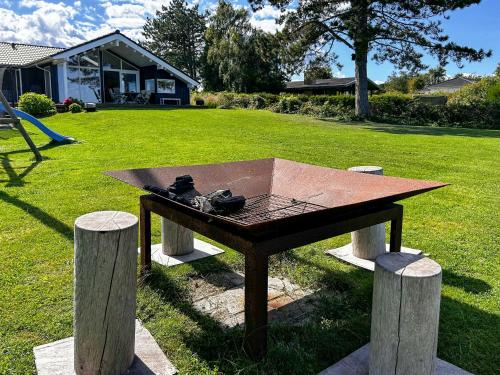 a picnic table in the grass in a yard at Beachfront Holiday Home Near Dalby Bay in Mesinge