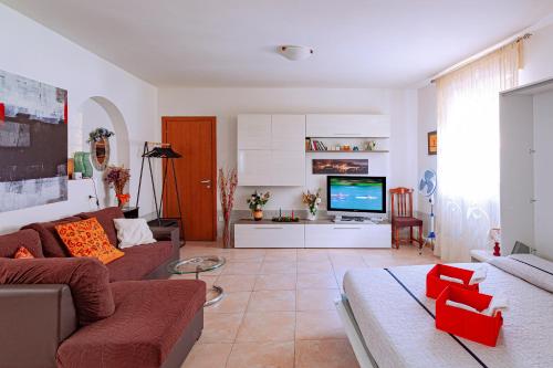 a living room with a couch and a tv at Open Space Valnerina in Piedipaterno