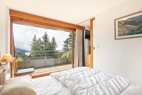 Un dormitorio con una cama y una ventana grande. en Epicéa E22 - Station de ski à pied, en Chamrousse