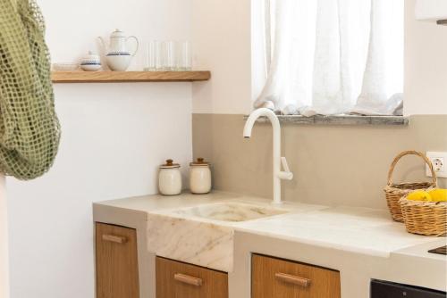 a kitchen with a sink and a window at Aelios Cycladic house in Nisída Planítis