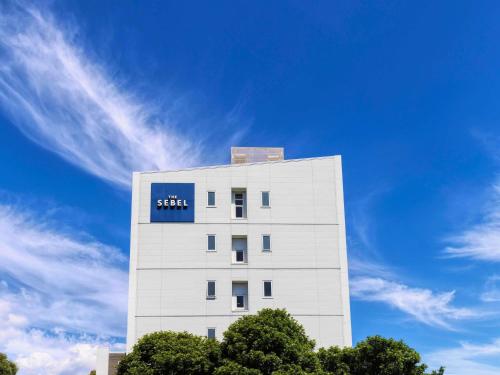 a white building with a blue sign on it at The Sebel Auckland Manukau in Auckland