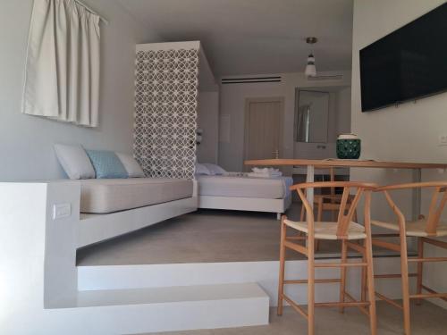 un soggiorno con un letto, un tavolo e delle sedie di Ostria village a Mylopotas