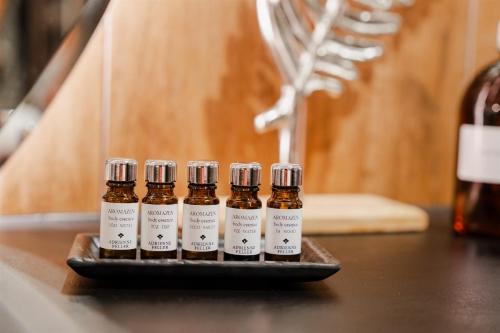 a group of four bottles of essential oils on a tray at Mamaison Hotel Chain Bridge Budapest in Budapest