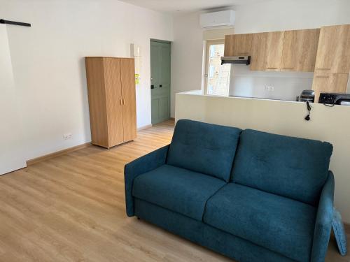Charmant appartement في فالنسيا: غرفة معيشة مع أريكة زرقاء ومطبخ