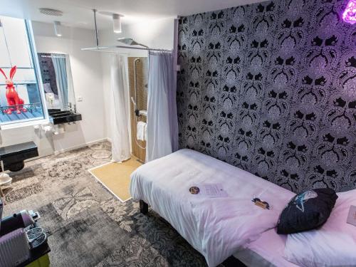 a bedroom with a bed and a purple wall at ibis Styles Lausanne Center MadHouse in Lausanne
