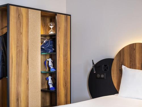 a bedroom with a bed and a cabinet with shoes at ibis Styles Paris Meteor Avenue d'Italie in Paris