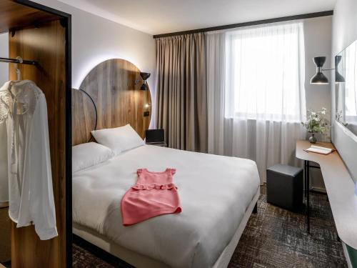 a hotel room with a bed with a pink dress on it at ibis Styles Paris Meteor Avenue d'Italie in Paris