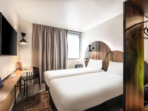 a hotel room with two beds and a desk at ibis Styles Paris Meteor Avenue d'Italie in Paris