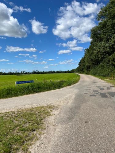 an empty road in the middle of a field at Hedegaard Holiday Apartments in Give