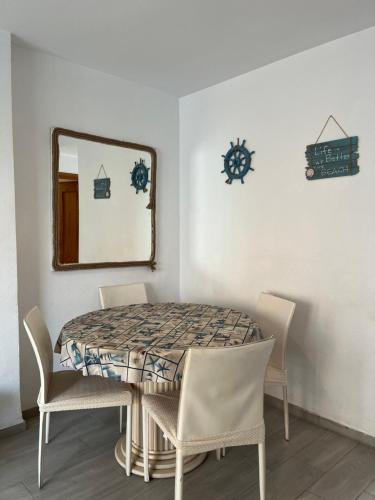 a dining room table with chairs and a mirror at Apartamento frente al mar, Talima in Denia