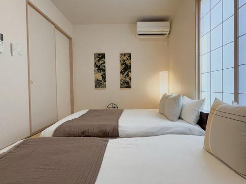 a bedroom with two beds and a window at Casa Stella 18 by Liaison in Osaka
