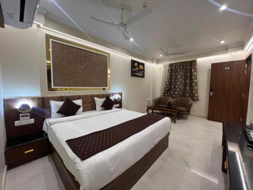 a bedroom with a large bed and a living room at The Hotel Sundaram Continental in Prayagraj