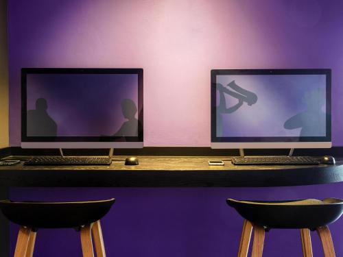 two computer monitors sitting on top of a desk at Ibis Styles Merida Galerias in Mérida