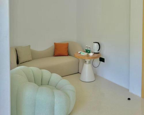a living room with a couch and a table at Nirvana Seaview Homestay in Wanning