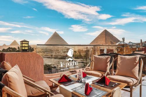 a patio with chairs and a view of the pyramids at Le Pacha BoutiQue Hotel in Cairo
