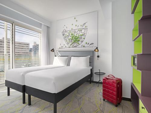 a bedroom with a bed and a red suitcase at Ibis Styles Jerusalem City Center - An AccorHotels Brand in Jerusalem