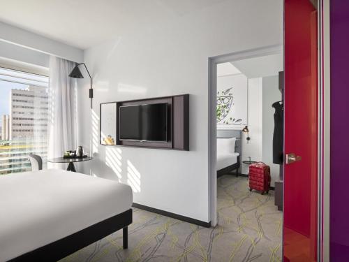 a bedroom with a bed and a tv on a wall at Ibis Styles Jerusalem City Center - An AccorHotels Brand in Jerusalem