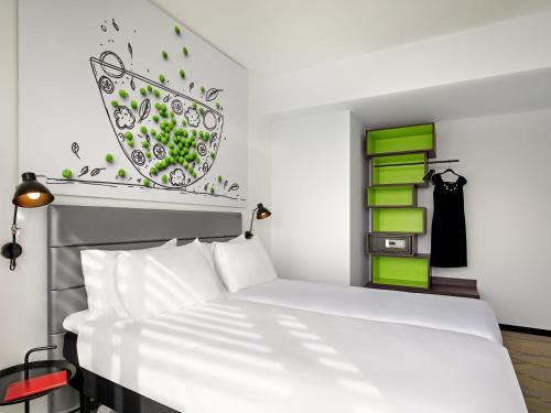 a bedroom with a white bed and green accents at Ibis Styles Jerusalem City Center - An AccorHotels Brand in Jerusalem