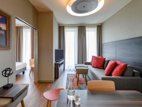 Télévision ou salle de divertissement dans l'établissement Aparthotel Adagio Bremen City