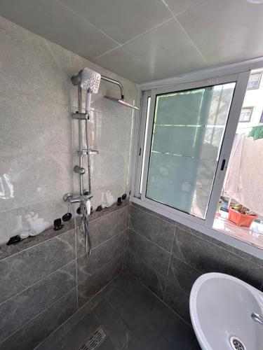 a bathroom with a shower and a sink and a window at إقامة الزهراء1مدينة سلا in Sale