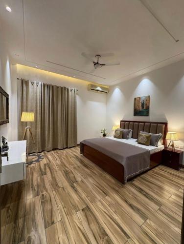 a bedroom with a large bed and wooden floors at Ayush residency in Varanasi