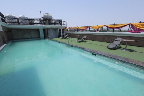 a swimming pool with blue water in a building at Hotel Wedcaton By Tivoli - Ambala in Ambāla