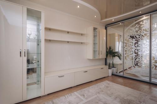 スームィにあるIllinska 2 rooms apartmentsの白い壁とガラスドアが特徴の広い客室です。