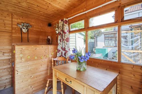 a wooden room with a table and a vase of flowers on it at Host & Stay - Windles in Tortworth