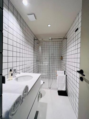 a white bathroom with a sink and a shower at Granja Premium House in Aveiro