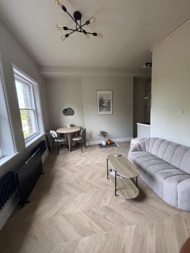 クリスタル・パレスにあるStylish 1 bed flat Londonのソファとテーブルのあるリビングルーム