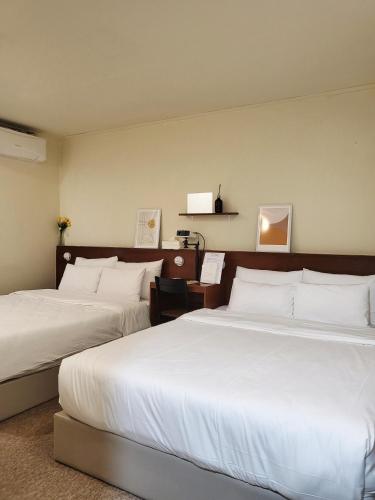 a hotel room with two beds with white pillows at jeonju hotel book and type in Jeonju