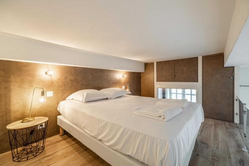 une chambre avec un grand lit aux draps blancs dans l'établissement Residence Garibaldi - Nice, à Nice
