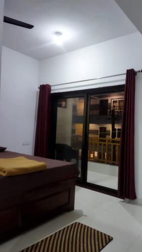 a bedroom with a bed and a large window at Prakash Holiday Inn in Arambol