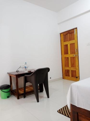 a room with a table and a wooden door at Prakash Holiday Inn in Arambol