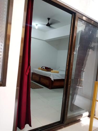 a mirror in a room with a bed in a bedroom at Prakash Holiday Inn in Arambol
