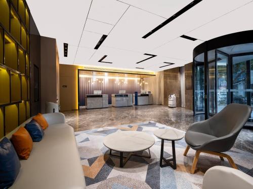 a lobby with a couch and chairs and tables at Holiday Inn Express Zhuhai Grand Theater by IHG in Zhuhai