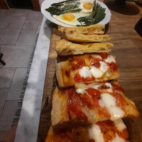 three slices of pizza on a cutting board with an egg at Pane e Marmellata in Signa