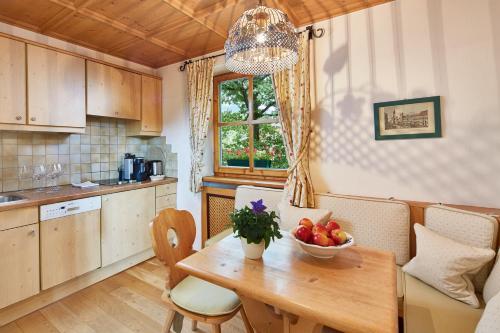 a kitchen with a table with a bowl of fruit on it at Landsitz Römerhof - Hotel Apartments in Kitzbühel