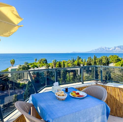 une table avec de la nourriture au sommet d'un balcon avec l'océan dans l'établissement Deluxe Ersoy Hotel, à Antalya