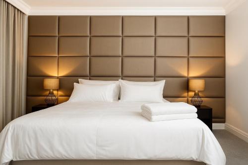 a bedroom with a large white bed with two lamps at Tranquil Haven in Cape Town