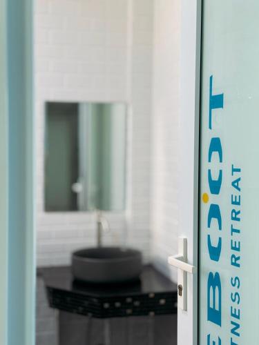 a bathroom with a sink and a mirror at Reboot Retreat Beach Resort, Restaurant, and Coffee Shop in Ban Talat Bang San