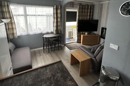 a living room with a couch and a table at Seaside Escape Chalet in Bridlington in Bridlington