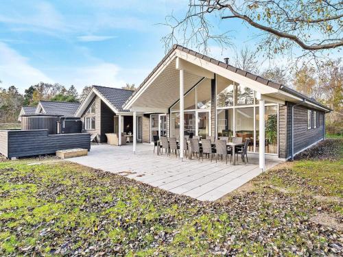 a house with a large deck with chairs on it at 14 person holiday home in Væggerløse in Marielyst