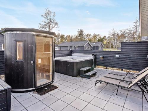 a large backyard with a hot tub on a patio at 14 person holiday home in Væggerløse in Marielyst