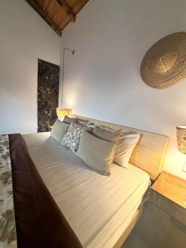 a bedroom with a large bed with pillows on it at Nazaara - Mukteshwar - Mountain view and sunset from your bed in Mukteswar
